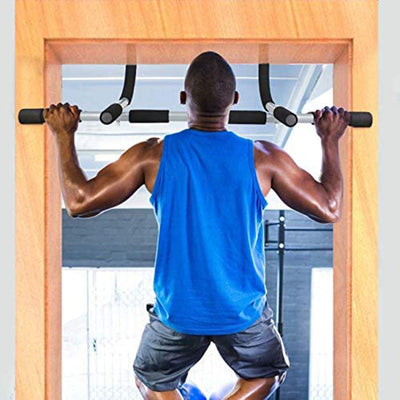 Man in a blue tank top and gray shorts doing pull-ups on a door frame.